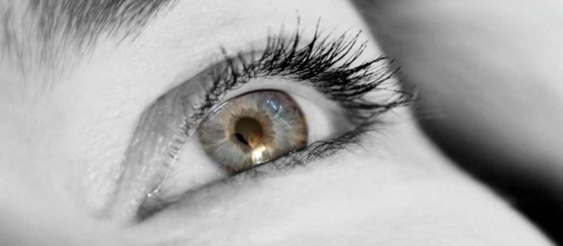 Close up black and white image of a ladies eye and eyelashes