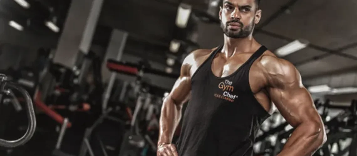 Juggy Sidhu standing in a gym wearing a black vest top